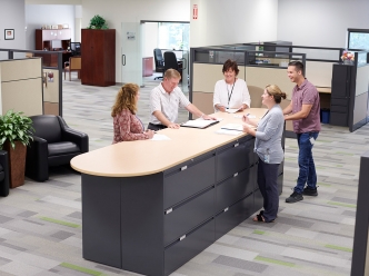 Account Management team huddle by the file cabinet